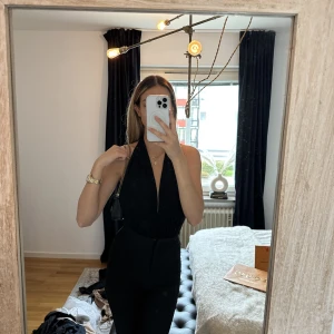 Body med öppen rygg - Fin glittrig svart body med öppen rygg, väldigt stretchig så passar många storlekar 