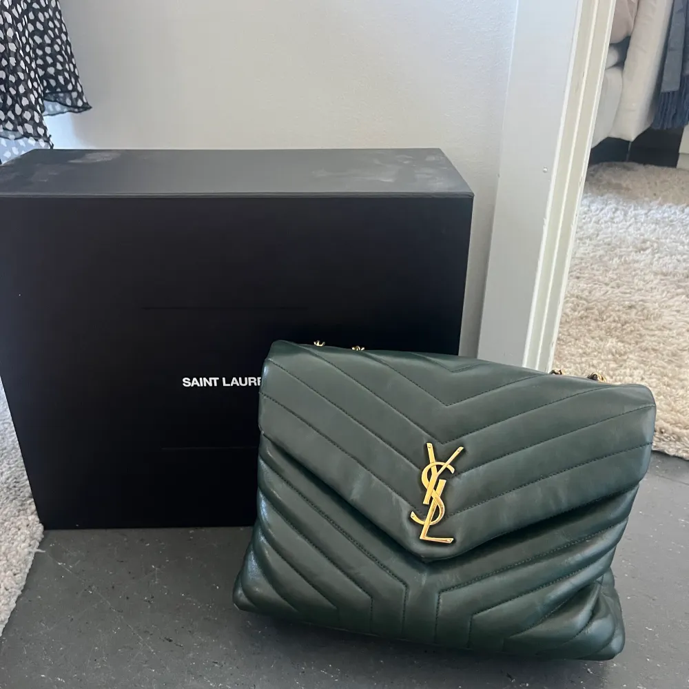 Säljer nu min super fina Saint Laurent Loulou väska i storleken medium. Färgen är ”Dark Green” och säljs inte längre i butik. Den är köpt på Saint laurents hemsida, dustbag, kvitto och box kommer med. Nypris ca 32000kr.. Väskor.