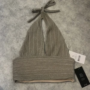 Glittrig topp - Säljer en glittrig halterneck topp från NA-KD i storlek XS då den är för liten för mig 🩷 (Köparen står för frakt)