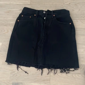Svart Levis kjol - Svart Levis kjol i bra skick. Storlek 27. Hamnar ovanför knäna (165 cm lång). 