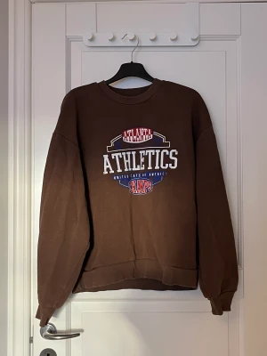 Brun tröja  - Ser nästan oanvänd ut. Trycket är inte skadat utan ska se så ut. 