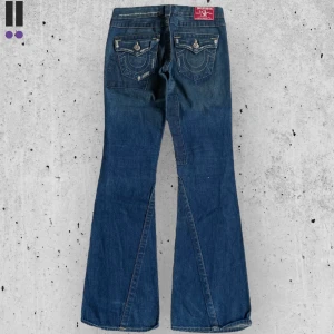 lågmidjade true religion 706 bootcut  - True Religion jeans i model Joey med custom distressing o grejer 💜 Tag 26W 💜Midja (rakt över) 36cm 💜 Innerben 83cm 💜 Ytterben 102cm 💜 Benöppning 24cm 💜 Cool design på fram & baksida 💜Våra mått blir W=28, L=32 💜 Men jämför alltid måtten💜706