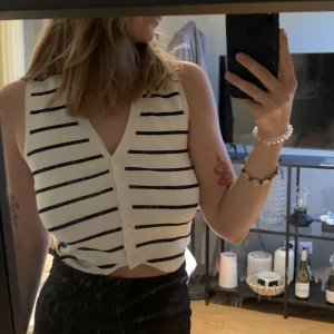 Topp från zara  - Vit/svart randig topp som har en form av en väst med knappar ifrån zara i storlek S. Aldrig använd. Material: viskos och polymide🌷