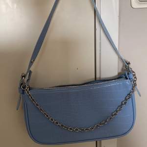 En blå handväska med orm mönster, kedjan går att ta av eller stoppa in! Jättebra skick