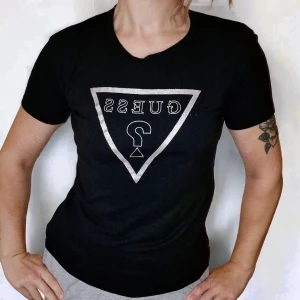 Y2K topp från GUESS babytee storlek M 2000-tal - En 2000's Y2K topp från Guess i fint skick! Storlek M, viss stretch. Silvrigt tryck utav loggan på bröstet. På foto nr 2 har jag vikt upp tröjan lite. Använd gärna köp-knappen 💖💖💖