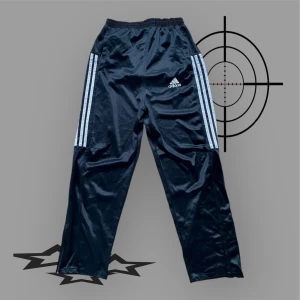 Vintage Adidasbyxor Loosefit - Snygga loosefit Adidas polyester byxor, vintage och köpte från Storbritannien. I fint skick, blixtlås vid benen, i gott skick. Passar för en person som är 175-185 cm lång. Ifall högmidjat passar dem för 165-175 cm. För fler bilder eller mått kontakta mig💫