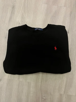 Polo Ralph Lauren tröja  - Säljer min Polo Ralph Lauren tröja i storlek L. Färg: svart. Nypris 1800. Tröjan har en avvikelse (litet hål) på nedre högra delen av tröjan. Men inget märkbart. Tröjan är dessutom svart så det syns inte. Det är något man kan fixa.