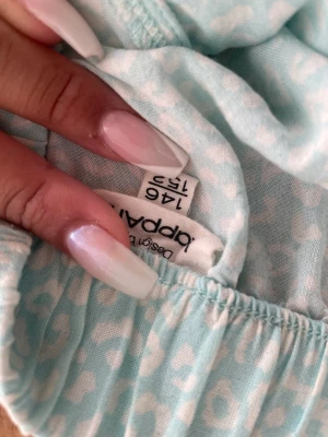 Grön lång kjol - Säljer denhär turkos blommiga kjolen i storlek 146-152, använd 1 gång bara för en skolavslutning 