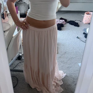 Lågmidjad kjol - Säljer denna lågmidjade rosa kjolen med lite spets längst ner, säljer då den är för lång för mig den är nästan helt oanvänd 