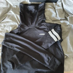 Stronge är tränings hudie kort - Det är en strong hudie som är av den kortare varianten med hög hals! Snörena där uppe är borta! Anars som ny!