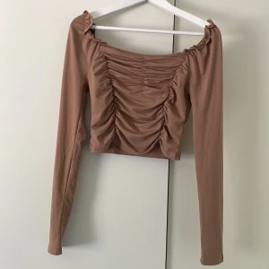 Rynkad blus  - Figurnära blus i strechigt material. Bild 2 & 3 är samma blus i svart, för att se passformen. 