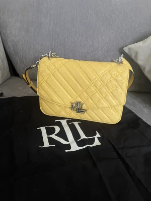 Lauren Ralph Lauren - Säljer min fina gula väska från Ralph Lauren. Väskan är använd litegrann och är i ett bra skick.  Nypris 2795