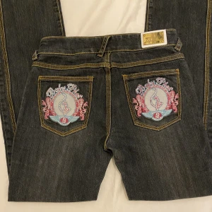 Baby phat jeans - Skick 10/10. Midja: 36cm. Skrev till midja: 20cm. Lår: 26cm. Innerbenslängd: 81cm. Benöppning: 19cm