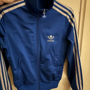 Adidas wct tröja xs  - Koboltblå adidas wct tröja/kofta, storlek 34, använt bra skick, lite avskavt färg på märket dragkedjan. 