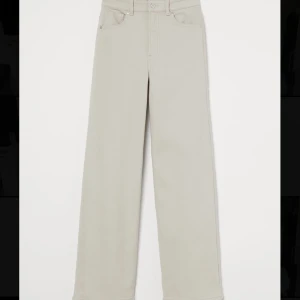 Beige Byxor - En par twillbyxor från H&M Divided i storlek 42. Vida ben och hög midja. 2% Elastan. Aldrig använda, lappar sitter kvar.