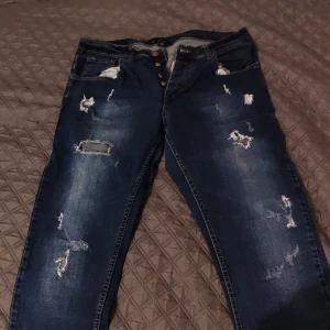 Rivna dsquared2 jeans med hål - As snygga dsquared byxor men de ser inte bra ut på mig så jag säljer dem, den e perfa kondition. Org. pris runt 3000, säljer för 700 bara för att jag vill at dem ska ut.
