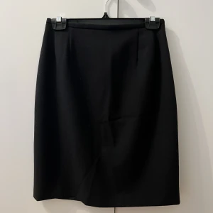 Kjol - Kjol med dragkedja och slits baktill, lite kraftigare tyg.  Märke- Ril’s