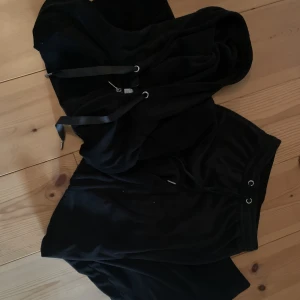 Mjukissätt - Svart mjukisset från ginatricot. Lite använt men fortfarande mysigt. Tröjan är i storlek xs och byxorna i storlek xxs, byxorna har ett minimalt hål på ena knät men syns inte vid användning.