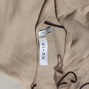 nu-in beige klänning - Beige klänning i organisk bomull med svart broderad blomdetalj från nu-in. Skönt material, säljs inte längre hos nu-in. 🌼🖤 