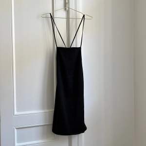 En svart miniklänning ifrån hm som går att knyta baktill för att få en bättre passform 