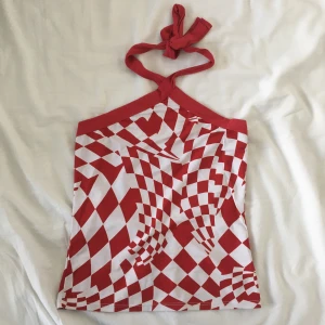 Röd och vit halternecktopp - Röd och vit halterneck från New Look, knyts i halsen. I superfint skick från min systers garderob. Skön i sommar! Osäker på storlek men väldigt stretchig, så bör passa flera! Mått: bredd mellan armhålorna 31.5 cm, längd ca 45 cm. 