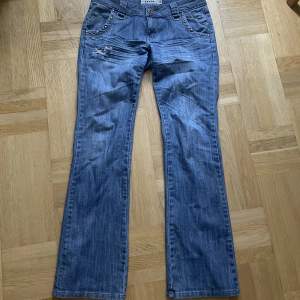 Lågmidjade jeans med fina detaljer. Säljer för att de tyvärr är för stor på mig💙 innerbenslängden 84 cm och midjemåttet är 43-44 cm