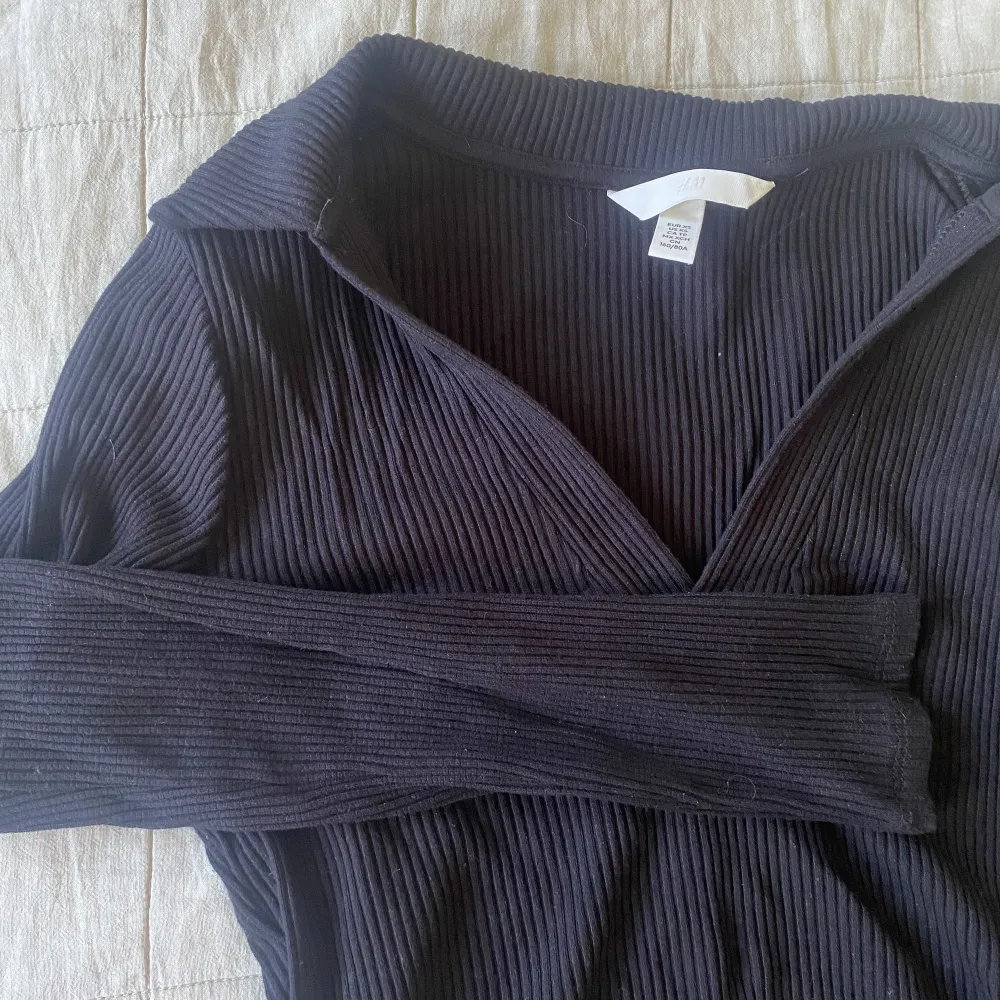 En svart ribbad tröja från H&M i storlek XS, knappt använd! . Toppar.