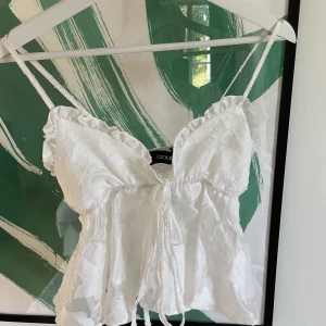 Volangtopp - Superfin topp med volanger och blommigt mönster. I princip aldrig använt.