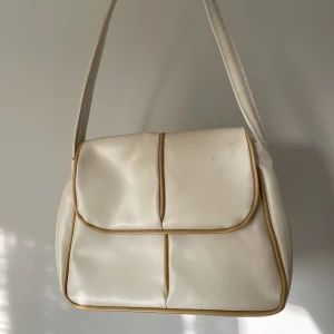 Väsa i krämvitt - Liten axelväska i krämvitt. Väldigt bra skick!