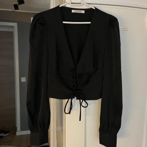 Svart tröja - Skick som ny, aldrig använd tröja. Justerbart band över magen. Storlek 34