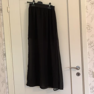 Lång kjol - Svart luftig långkjol med två slits på varsin sida 
