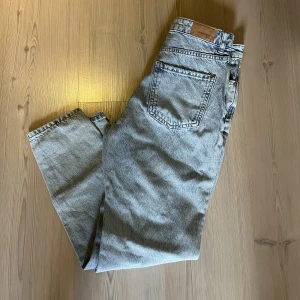Gina Tricot jeans  - Ljusblåa mom jeans med hål på vardera knä från Gina Tricot i storlek 32. Högmidjade. Hålen har blivit lite uttöjda (se bild) men går absolut att använda fortfarande! I övrigt bra skick. 70kr plus frakt. Har mycket fler plagg tillsalu! 