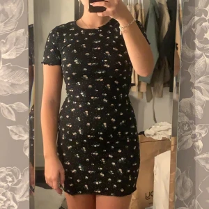 Klänning  - Fin blommig svart klänning, fint skick använd minst tre gången, säljer då den börjar bli lite liten, stl xs.