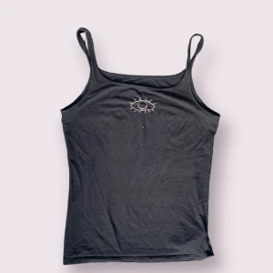 Linne med broderidetalj - Svart stretchigt linne med broderat öga. 