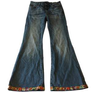 Coola jeans med blommor på från Crocker! Midjemått 75cm Innerbenslängd 73cm Grenmått 24,5cm
