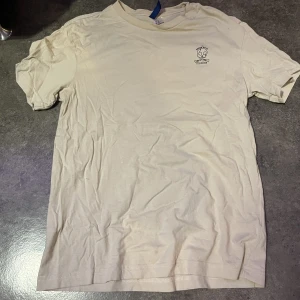 Beige T-shirt  - En vanlig beige T-shirt me ett tryck på. Säljer denna T-shirt då ja aldrig använder den. Bra skick 