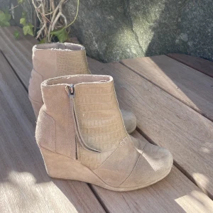 Toms boots med klack - Ett par jättefina boots med klack från Toms i en fin beige färg och i mocka. Jättefint skick!