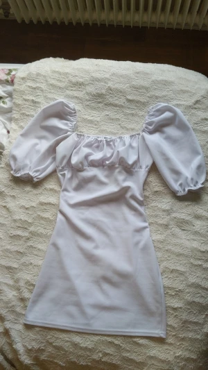 Vit sommar klänning - Puff ärmar och vid brösten. I och med att den är vit är den lätt genomskinlig om man inte har rätt underkläder under. Formar kroppen fint. Perfekt till studenten eller som en fin sommarklänning