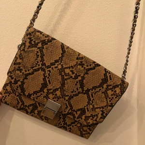 Väska från Zara - Brun väska från Zara i ”ormmönster”. Fint skick!