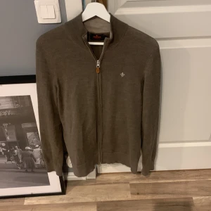 Morris Zipup - Säljer nu min Morris zipup. Väldigt snygg och som ny. Den är beige/brun och i materialet marino wool. Relativt tunn och perfekt nu till sommaren  o våren. Vid frågor eller bud är det bara att skriva. Nypris ca 1800