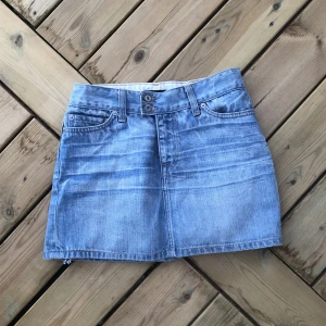 Jeanskjol  - Jeanskjol köpt second hand som är väl andvänd men har inga tydliga defekter. Har sytt in på sidorna men det syns inte på utsidan. 70 cm midjemått och mått från midjan ner är 35 cm. storleken på lappen är m men den är insydd till typ xs. 