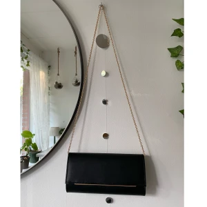 Kuvertväska svart - Säljer denna superfina axelremsväska från Anna field :) den är svart och har en guldig kedja. Perfekt för skolbal, studenten, fester eller bara till vardag. Material: skinnimitation🌱 Använd fåtal gånger. Skriv om du har frågor✨H: 12 cm, B: 5 cm, L: 24 cm