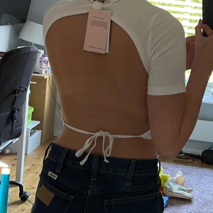 Ny tröja Monki  - Supersöt crop top från monki. Den har öppen rygg som knyts där bak med band. Helt oanvänd, lappen sitter kvar Storlek: XS