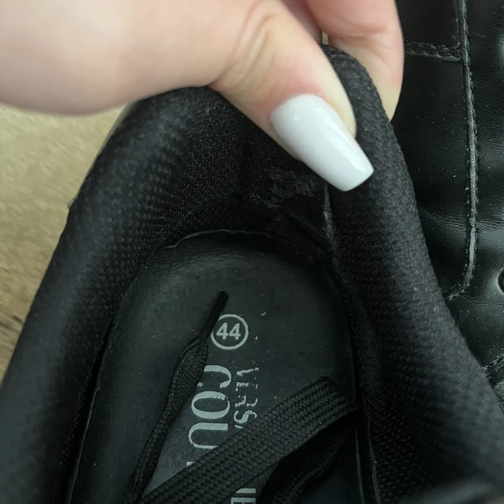 Svarta Versace sneakers i storlek 44. Liten skada vid hälen i båda skorna, märks ej av vid användning.. Skor.