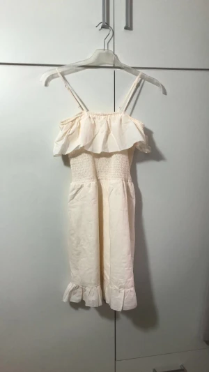 Klänning - Fin klänning till stockholmsstilen, har dock en väldigt liten smink fläck som enkelt går att ta bort.