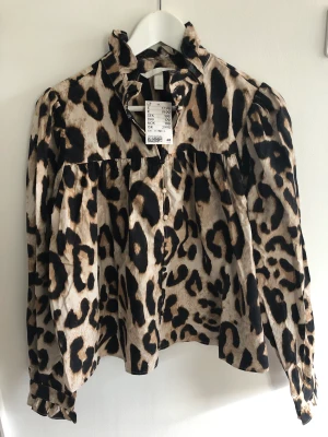 Leopard-blus - Oanvänd blus i leopardmönster med hög krage och knäppning 