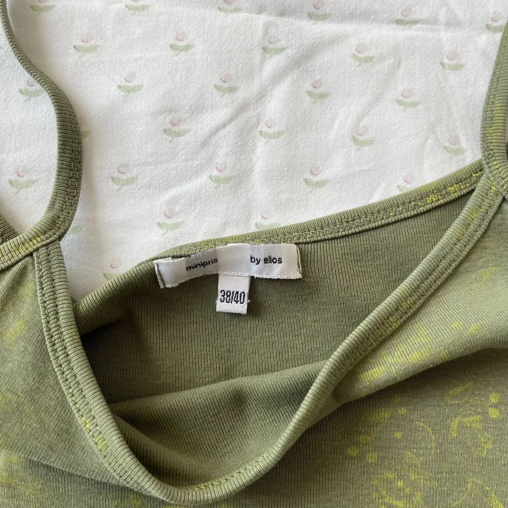 Grönt linne med gula detaljer 💚💛 . Toppar.