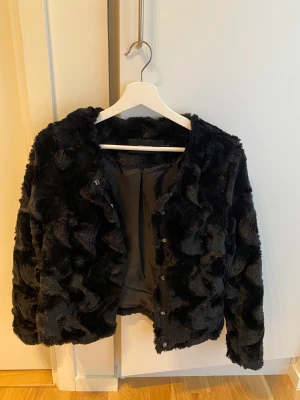 Svart jacka - Jacka i fuskpäls. Använd ett fåtal gånger, fint skick!