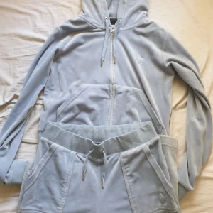 Blåa juicy Couture sett - Jag säljer mitt blåa juicy sett för att det längre inte används. Tröjan är i storlek M och byxorna är i storlek S. Jag har haft dom sen 2021 och används runt 10 gånger. Dragkedja har tappat färgen och är lite repade.