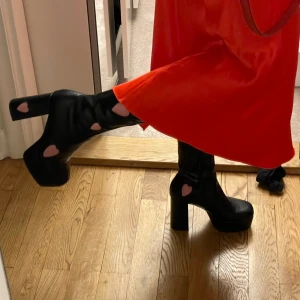 Knähöga la Moda boots stl 38 - Jättefina la Moda boots. Svarta med hjärtan på. Lite slitna längst fram på tårna pga användning 